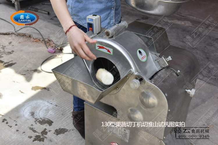 啟動(dòng)機(jī)器將小段淮山放入切丁機(jī)內(nèi)